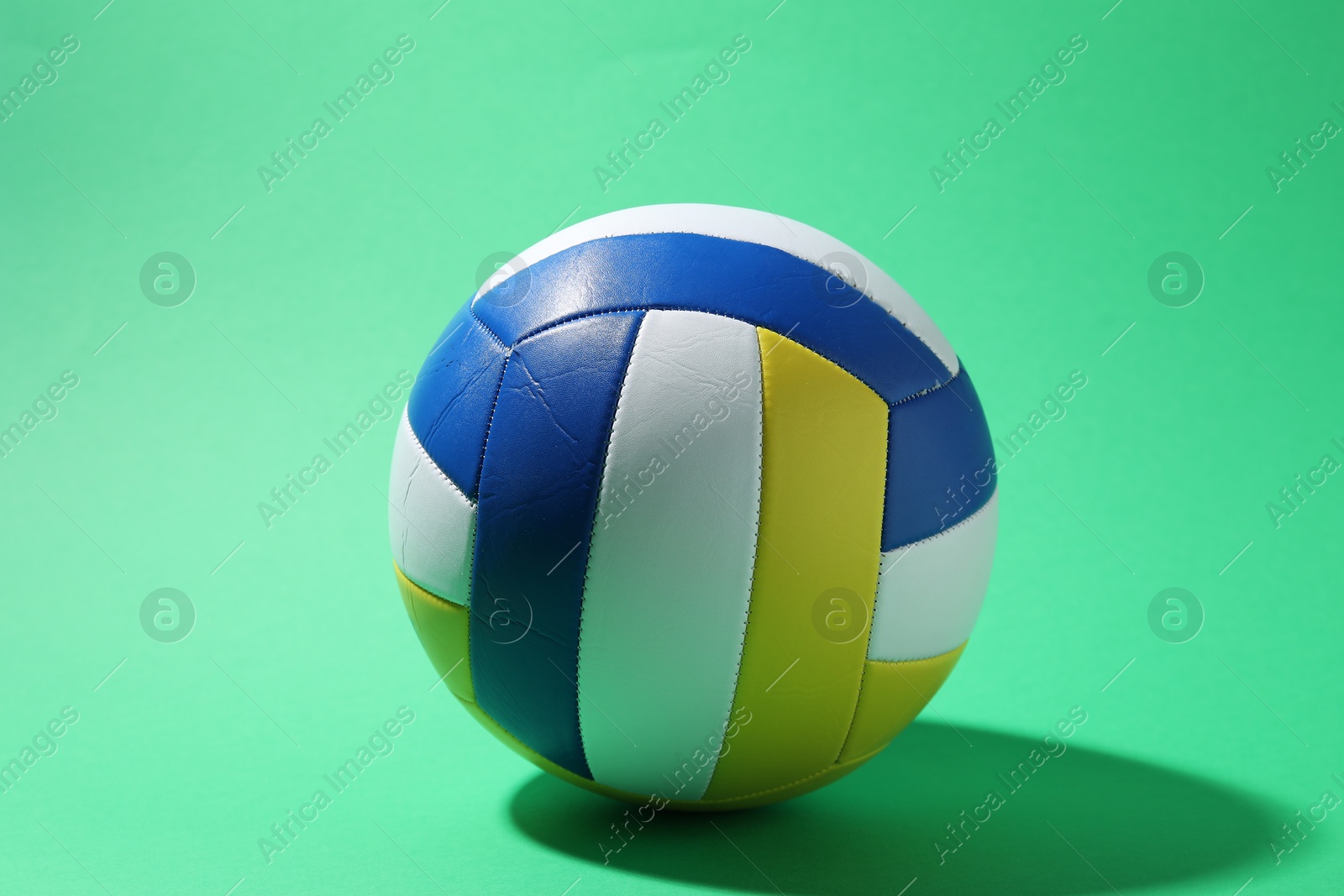 Photo of One colorful volleyball ball on green background