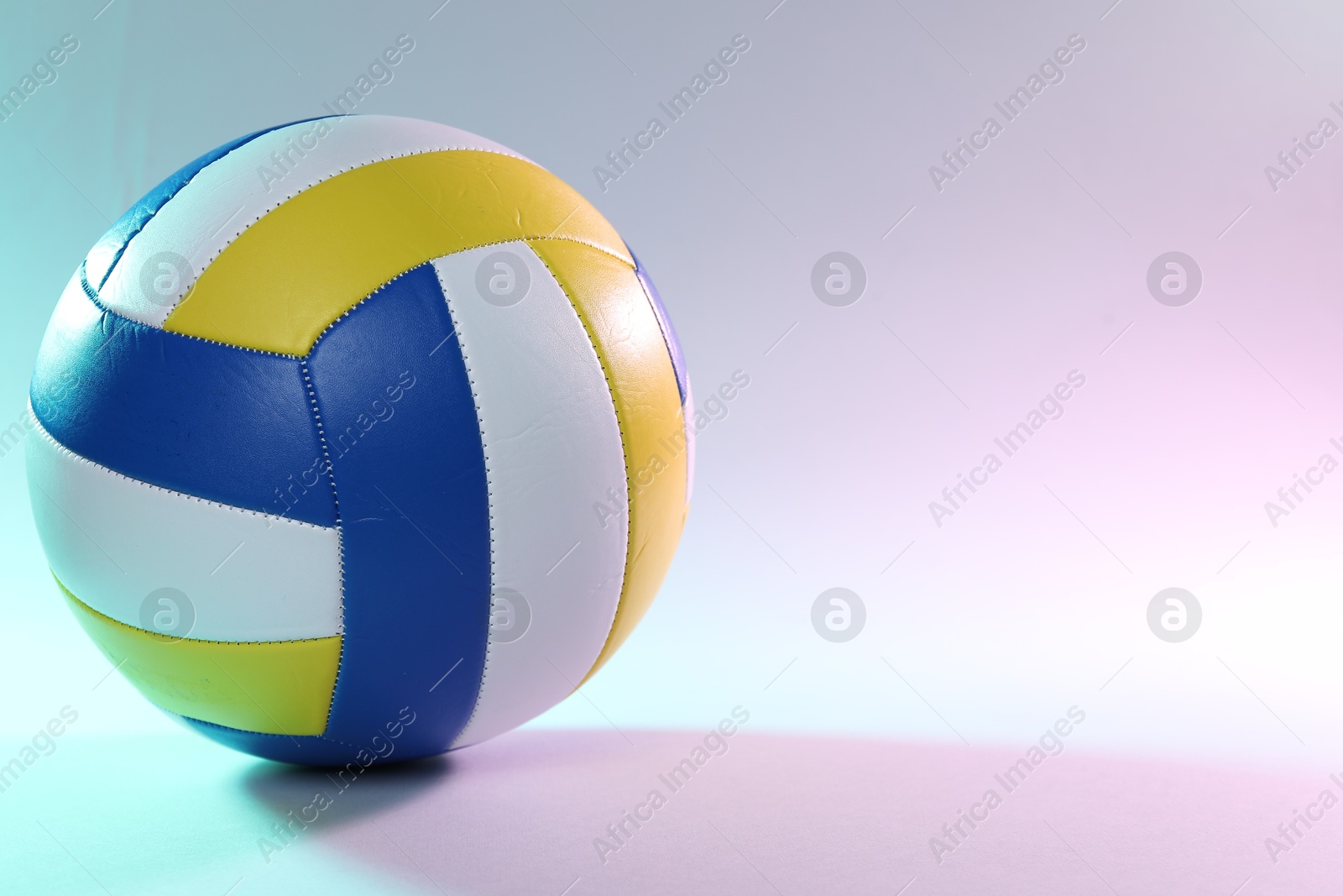 Photo of Colorful volleyball ball on light background. Space for text