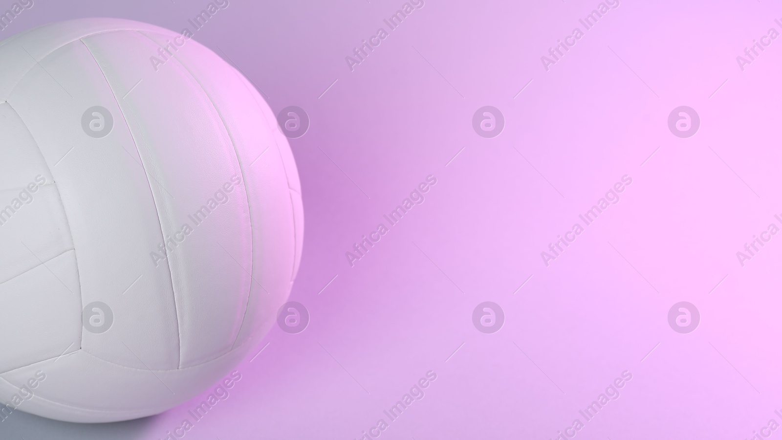 Photo of White volleyball ball on light background. Space for text