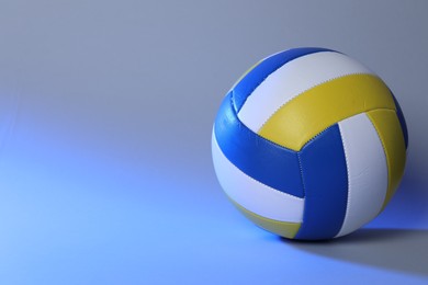 Photo of Colorful volleyball ball on blue background. Space for text