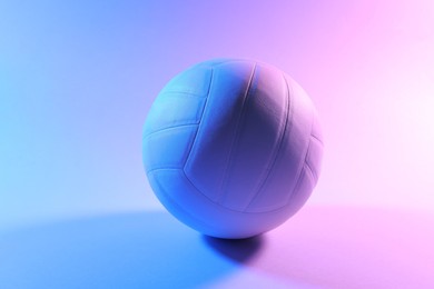 Photo of Volleyball ball on light background in color lights