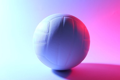 Photo of Volleyball ball on light background in color lights