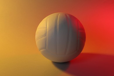 Photo of Volleyball ball on light background in color lights
