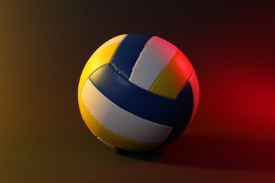 Photo of Volleyball ball on dark background in color lights