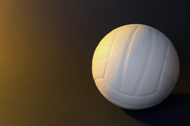 Photo of White volleyball ball on dark background. Space for text