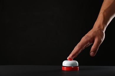 Photo of Man pressing button on black background, closeup. Space for text