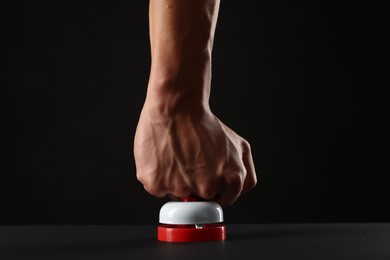 Photo of Man pressing button on black background, closeup