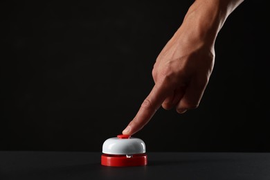 Photo of Man pressing button on black background, closeup. Space for text