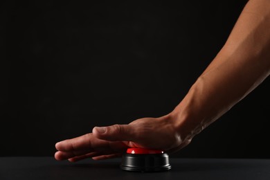 Photo of Man pressing button on black background, closeup. Space for text