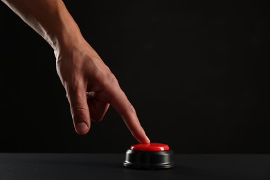Photo of Man pressing button on black background, closeup. Space for text