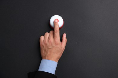 Photo of Man pressing button on black background, top view