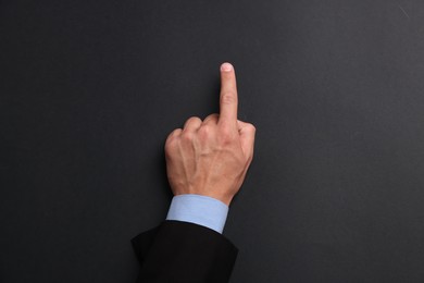 Photo of Man touching something on black background, top view