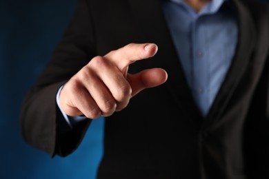 Photo of Man touching something on blue background, closeup