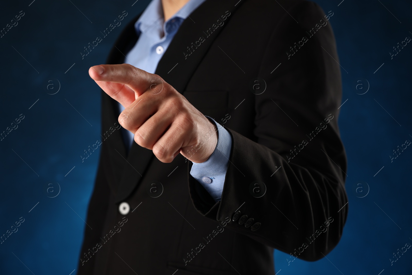 Photo of Man touching something on blue background, closeup