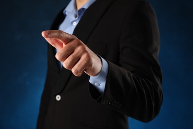 Photo of Man touching something on blue background, closeup