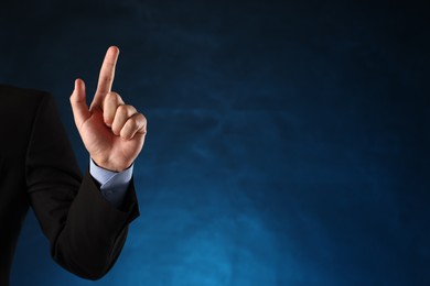 Photo of Man touching something on blue background, closeup. Space for text