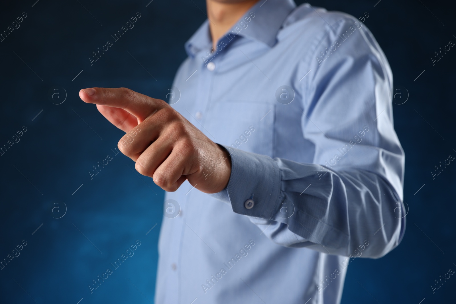 Photo of Man touching something on blue background, closeup