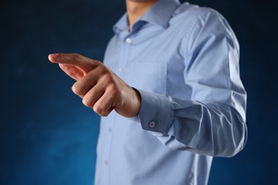 Photo of Man touching something on blue background, closeup