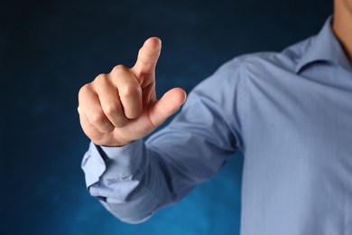 Photo of Man touching something on blue background, closeup