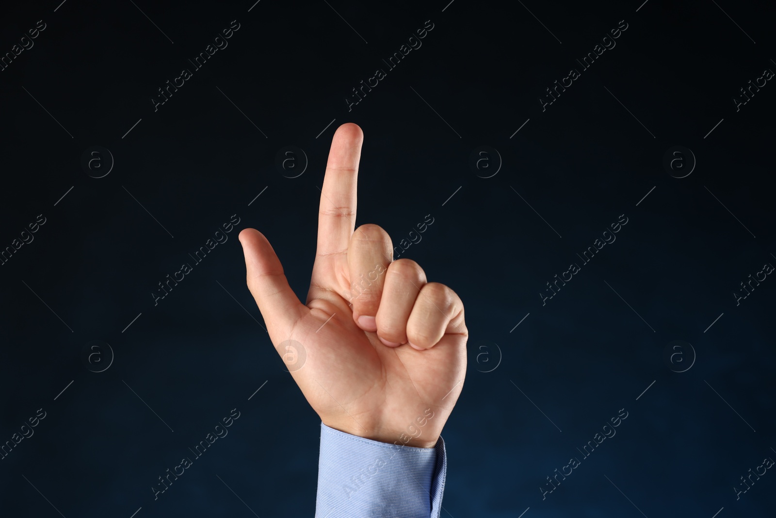 Photo of Man touching something on blue background, closeup