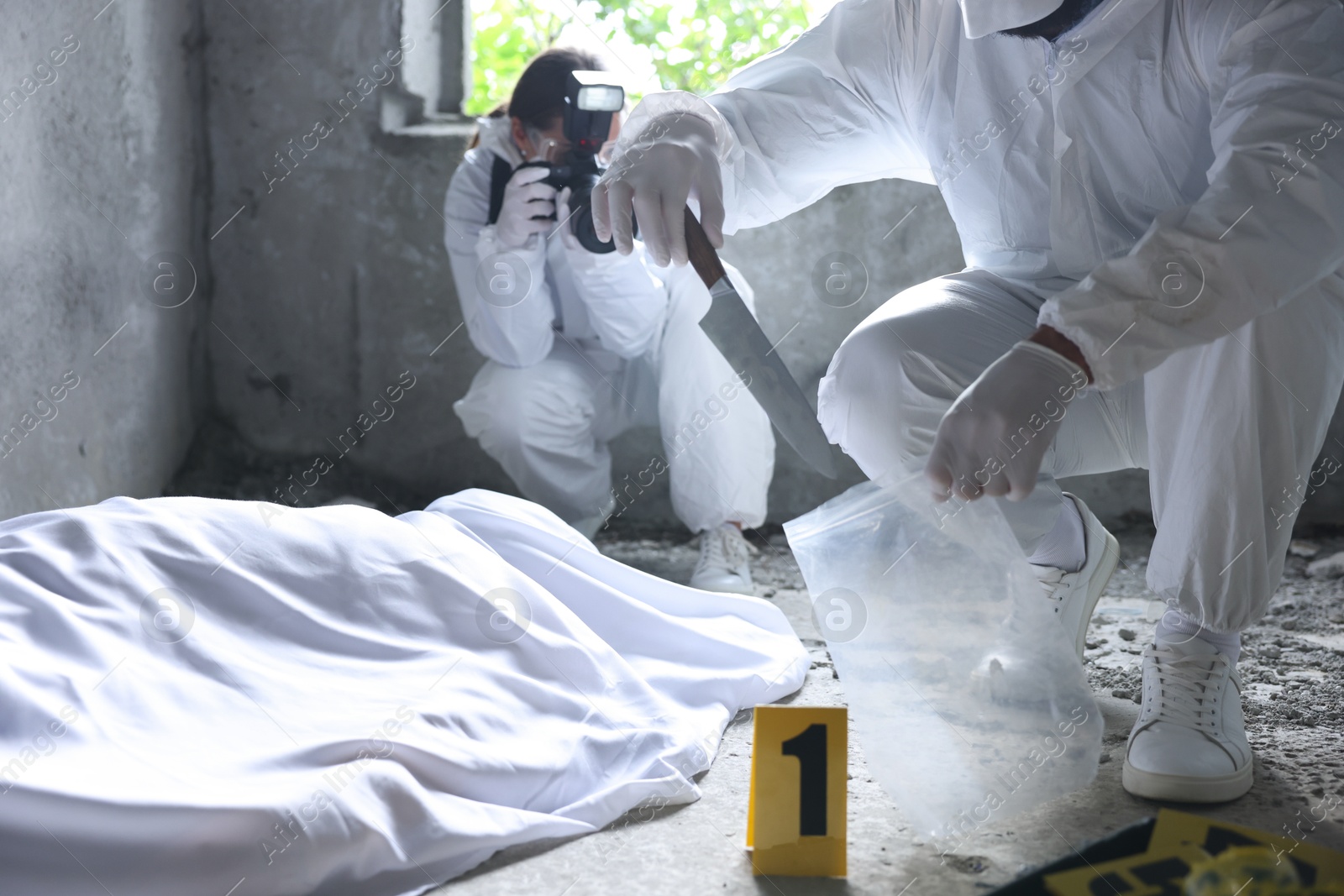 Forensic experts working at crime scene with dead body inside abandoned building Photo of Forensic experts working at crime scene with dead body inside abandoned building