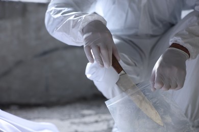 Photo of Forensic expert with evidence working at crime scene indoors, closeup. Space for text