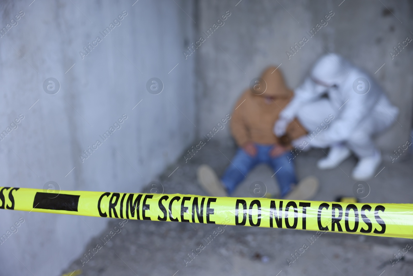 Forensic expert working at crime scene with dead body inside abandoned building, focus on yellow police tape Photo of Forensic expert working at crime scene with dead body inside abandoned building, focus on yellow police tape