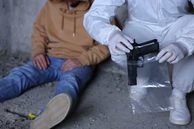 Photo of Forensic expert working at crime scene with dead body inside abandoned building, closeup