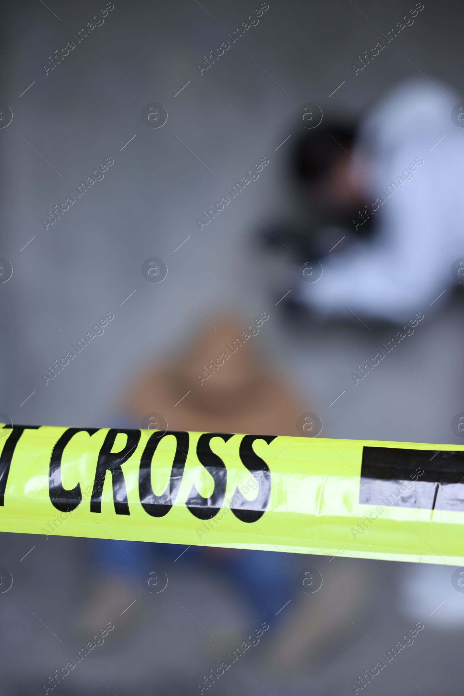 Forensic expert working at crime scene with dead body inside abandoned building, focus on yellow police tape Photo of Forensic expert working at crime scene with dead body inside abandoned building, focus on yellow police tape