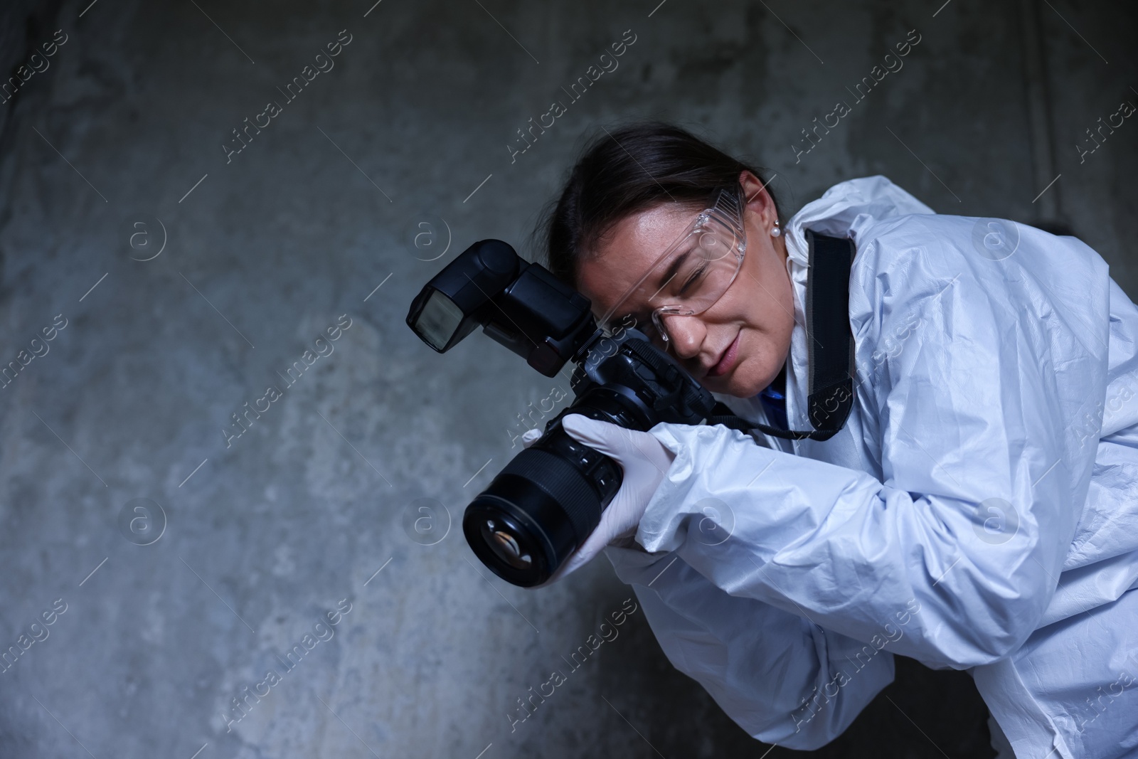 Forensic expert with camera working at crime scene inside abandoned building, low angle view. Space for text Photo of Forensic expert with camera working at crime scene inside abandoned building, low angle view. Space for text