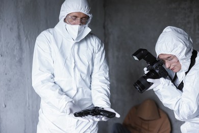 Photo of Forensic experts working at crime scene with dead body inside abandoned building