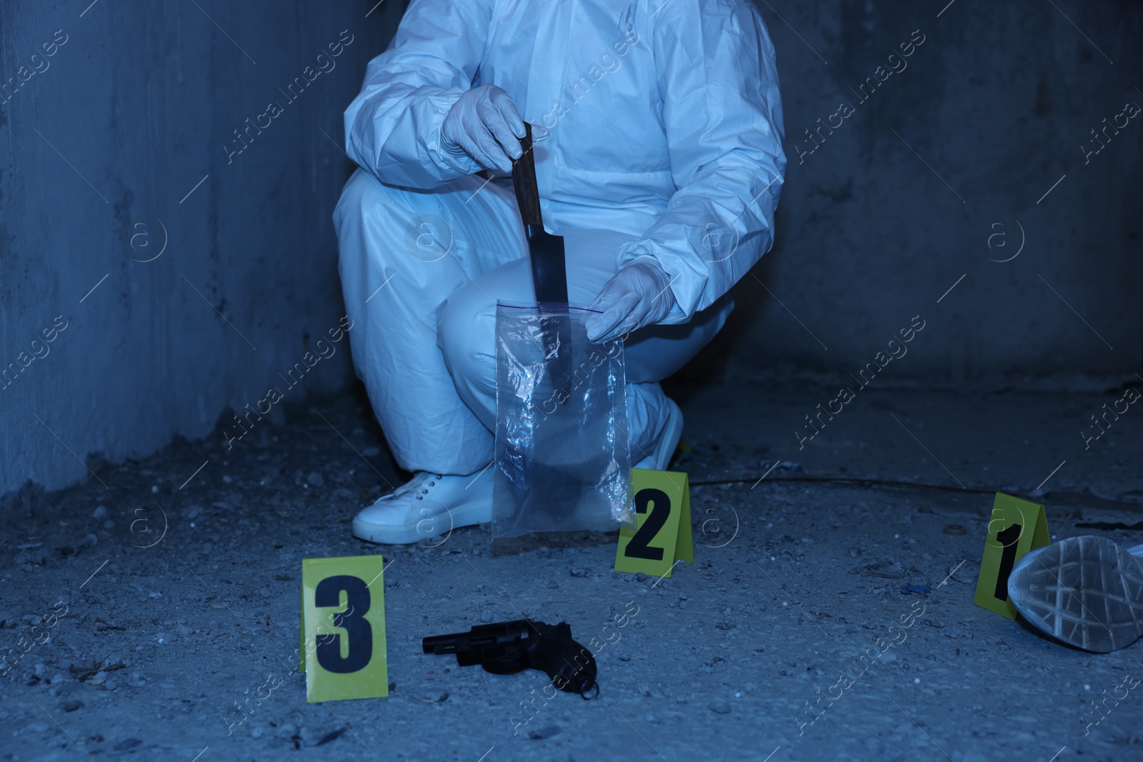 Forensic expert with evidence working at crime scene inside abandoned building, closeup Photo of Forensic expert with evidence working at crime scene inside abandoned building, closeup