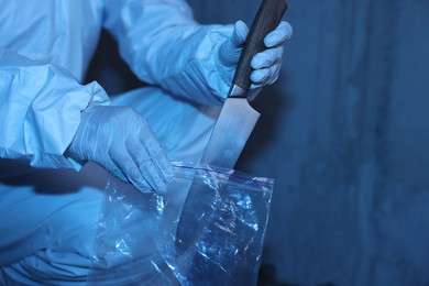 Photo of Forensic expert with evidence working at crime scene inside abandoned building, closeup. Space for text