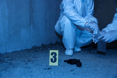 Photo of Forensic experts working at crime scene inside abandoned building, closeup. Space for text