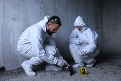 Photo of Forensic experts working at crime scene inside abandoned building