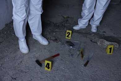 Photo of Forensic experts working at crime scene inside abandoned building, closeup