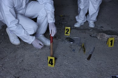 Photo of Forensic experts working at crime scene inside abandoned building, closeup
