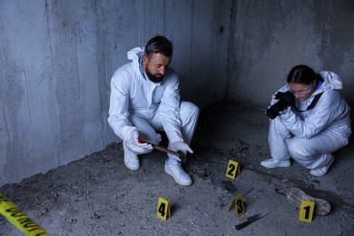 Photo of Forensic experts working at crime scene inside abandoned building