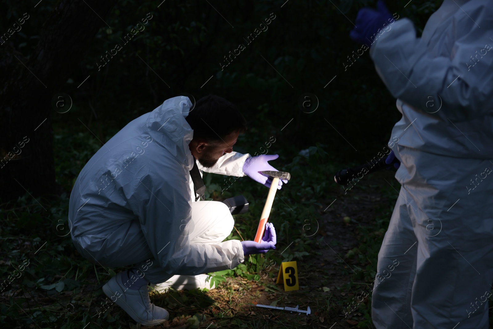 Photo of Forensic experts working at crime scene outdoors