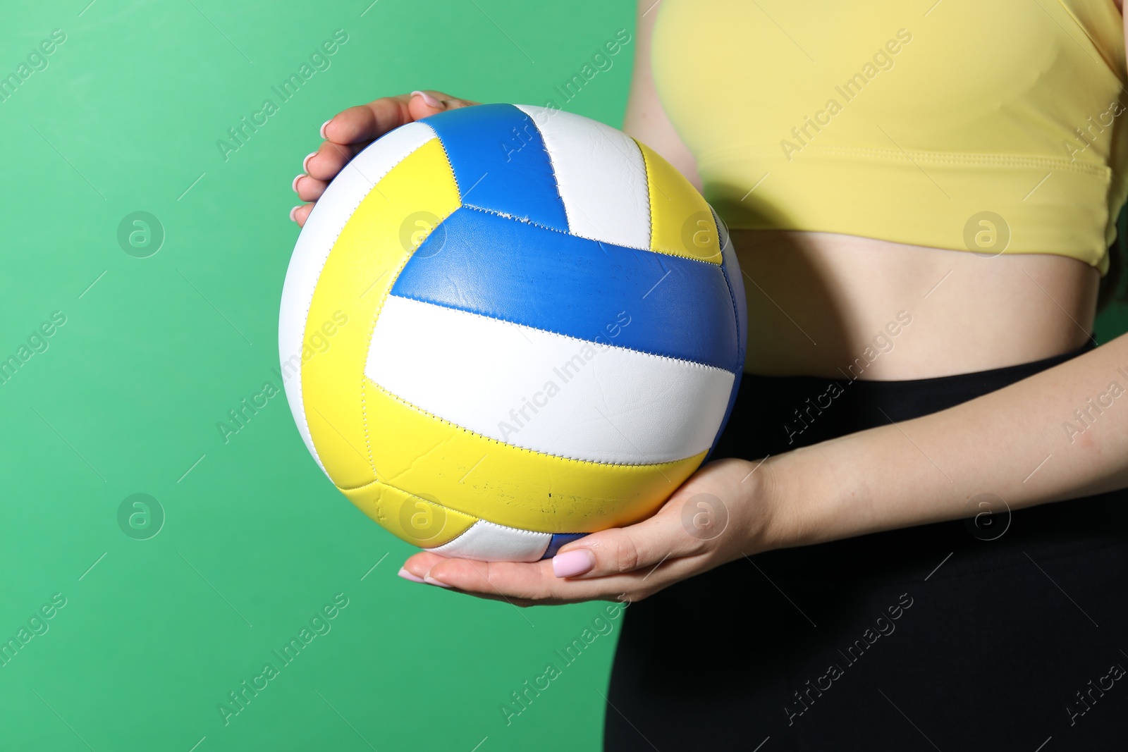 Photo of Woman with volleyball ball on green background, closeup