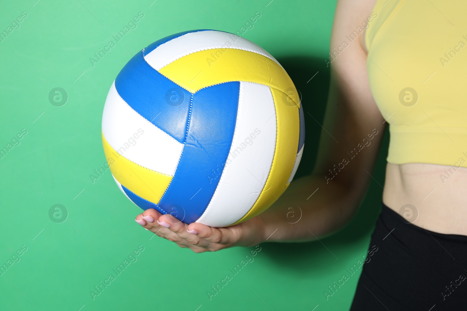 Photo of Woman with volleyball ball on green background, closeup