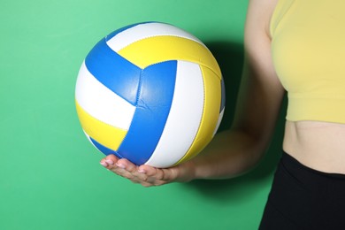 Photo of Woman with volleyball ball on green background, closeup