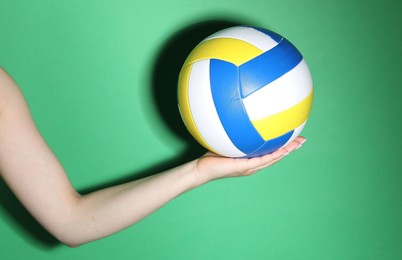 Photo of Woman with volleyball ball on green background, closeup