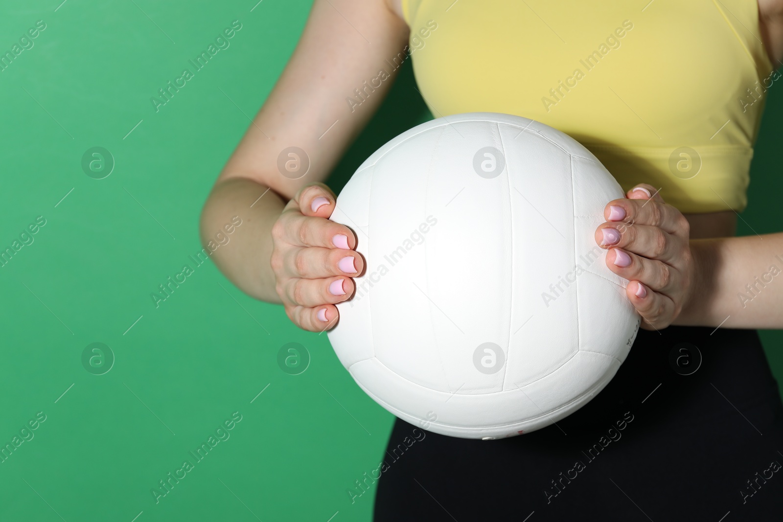 Photo of Woman with volleyball ball on green background, closeup. Space for text