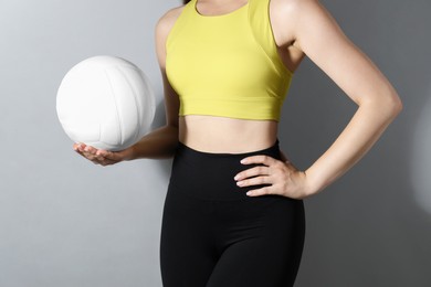 Photo of Woman with volleyball ball on light grey background, closeup