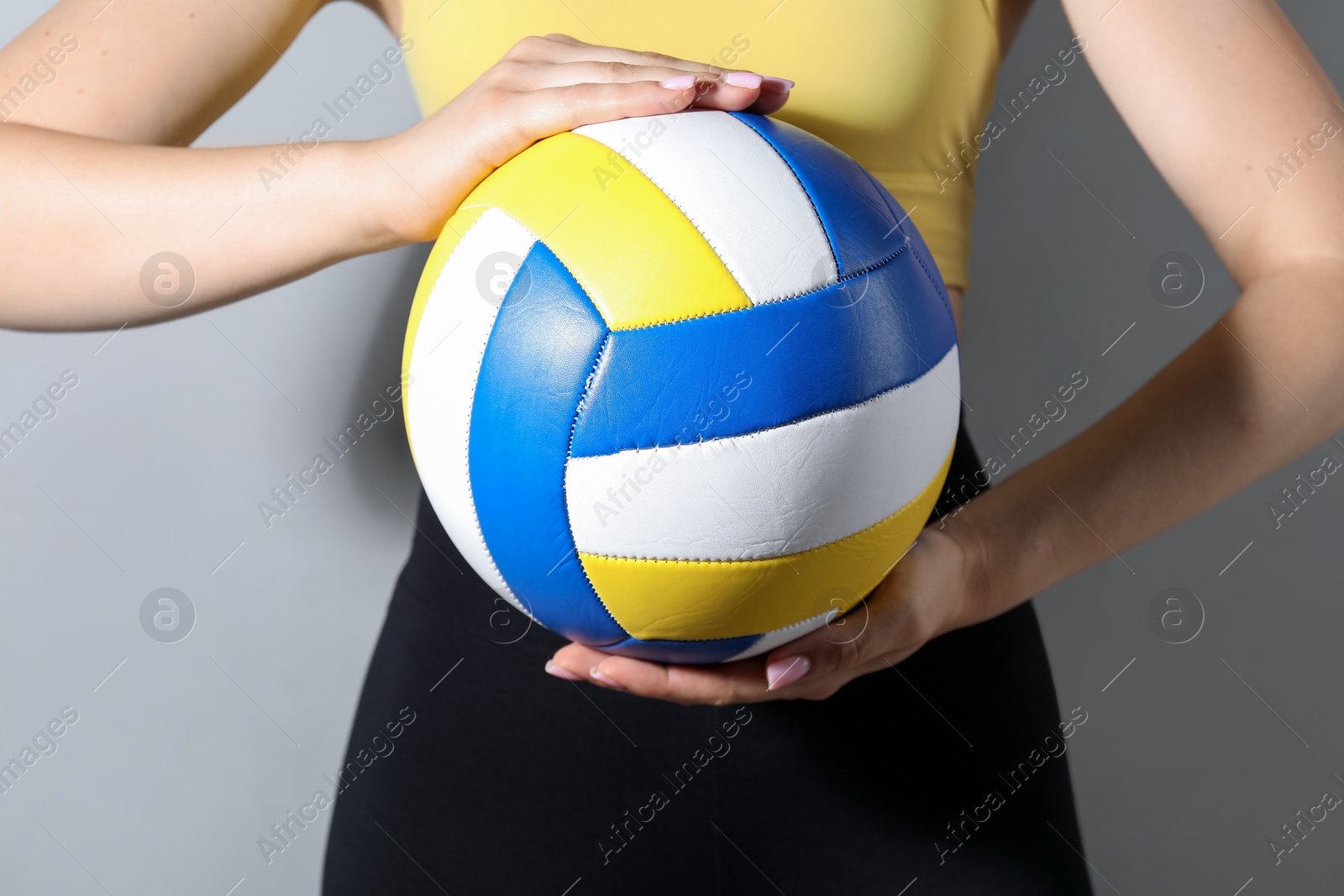 Photo of Woman with volleyball ball on light grey background, closeup