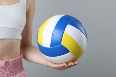 Photo of Woman with volleyball ball on light grey background, closeup