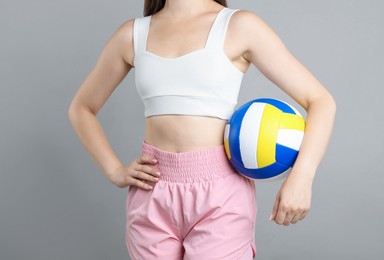 Photo of Woman with volleyball ball on light grey background, closeup