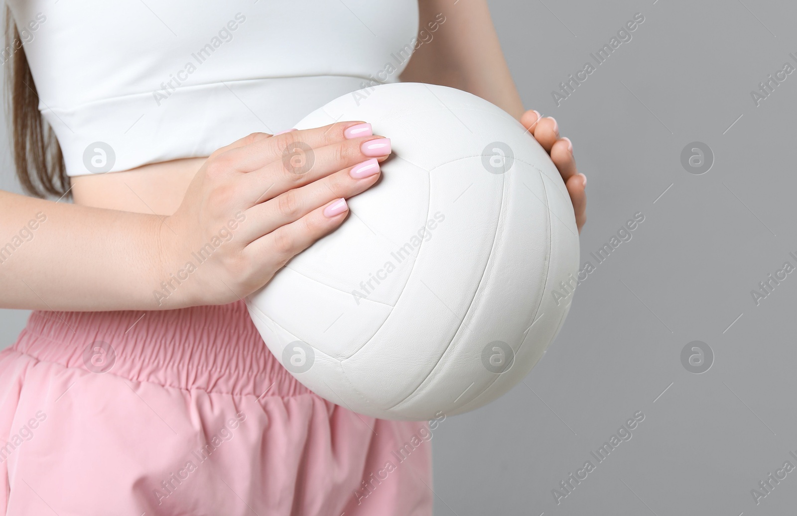Photo of Woman with volleyball ball on light grey background, closeup. Space for text