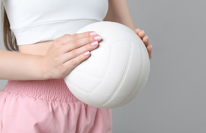 Photo of Woman with volleyball ball on light grey background, closeup. Space for text